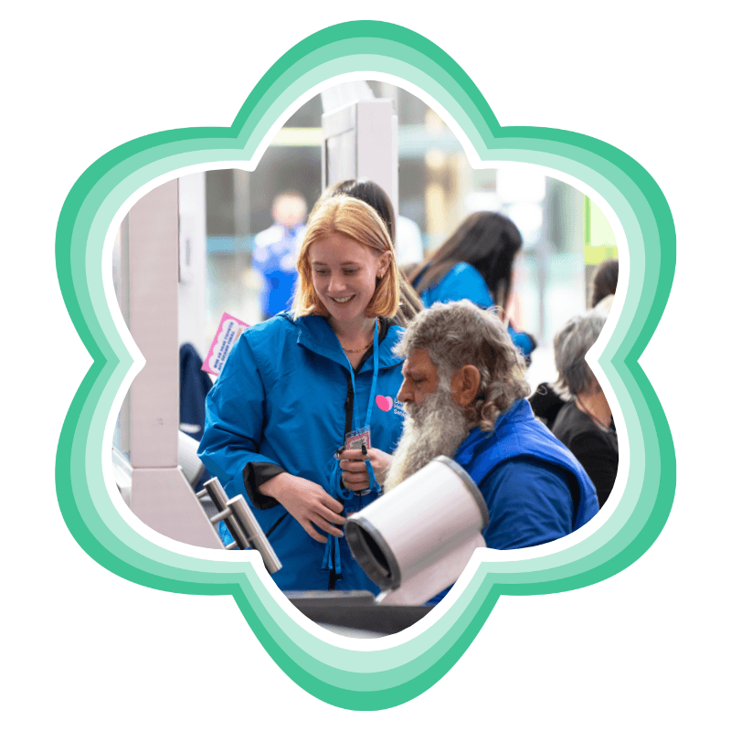 A Latrobe Health Services team member helping a man use a health check station